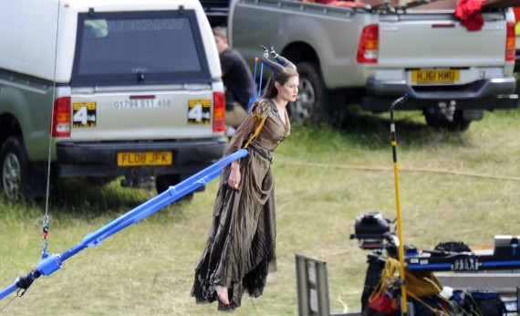 Angelina Jolie is hoisted into the air by a crane as she shoots scenes from the new Disney movie, 'Maleficent'. The 37-year-old actress, who is shooting the new movie in Buckinghamshire, England, stars as the title character - the evil Maleficent - in the film, a real-life version of the Disney cartoon Sleeping Beauty. Wearing her horned headdress, complete with prosthetic cheekbones and a long brown dress and matching cape, Jolie looked calm and confident as she was lifted up into the air by the crane, which was attached to her around the waist.Pictured: Angelina JolieRef: SPL410662  260612  Picture by: Almasi / Greg Sirc / Splash NewsSplash News and PicturesLos Angeles:	310-821-2666New York:	212-619-2666London:	870-934-2666photodesk@splashnews.com