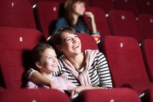Loughing mother and daughter at the cinema watching a movie
