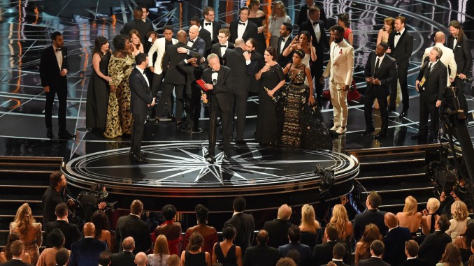 The cast of "Moonlight" and ""La La Land" appear on stage as presenter Warren Beatty (C), flanked by host Jimmy Kimmel (L) shows the winner's envelope for Best Movie "Moonlight" on stage at the 89th Oscars on February 26, 2017 in Hollywood, California. / AFP / Mark RALSTON        (Photo credit should read MARK RALSTON/AFP/Getty Images)